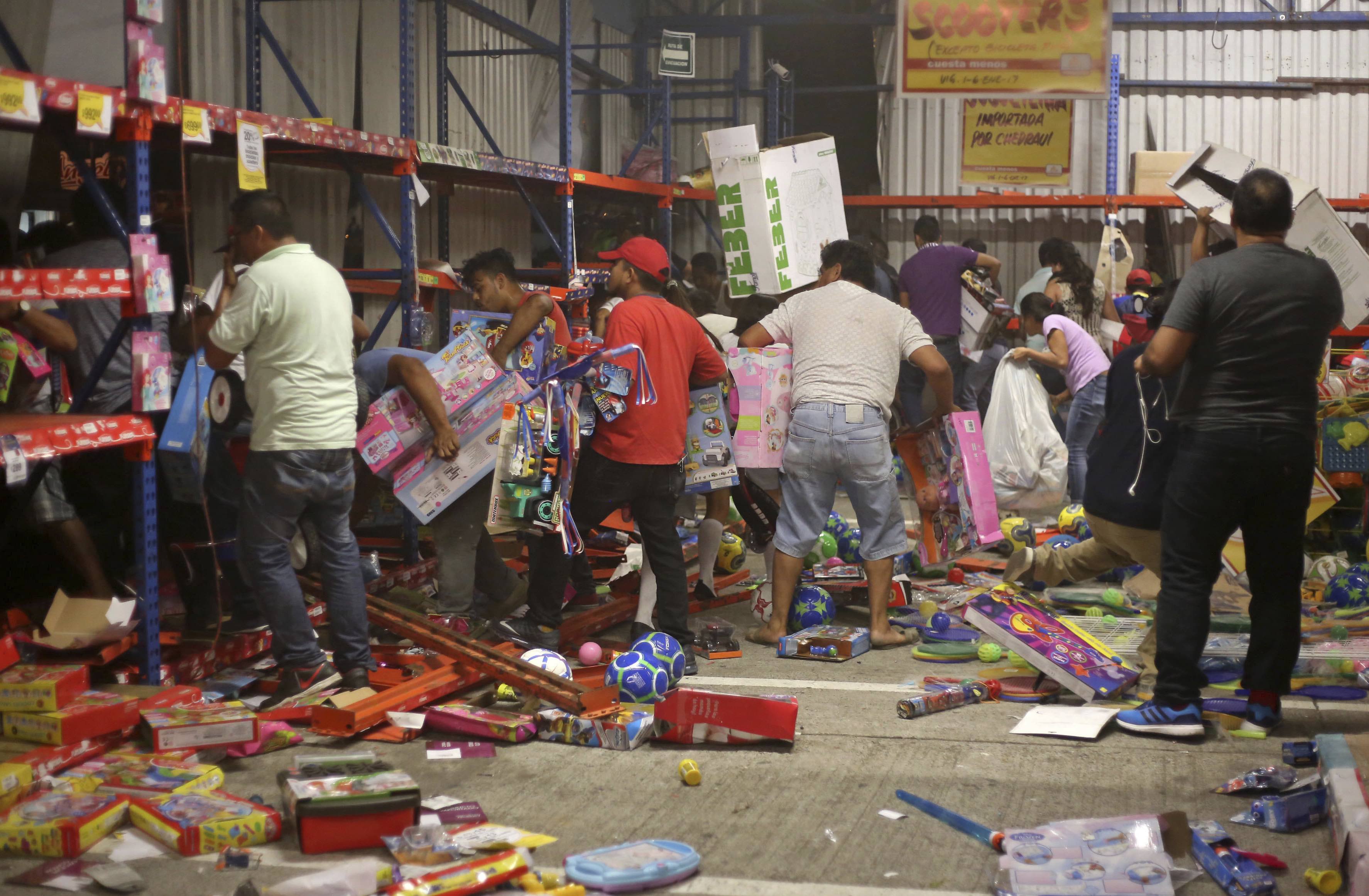 A group of people grabs toys as a store is ransacked by a crowd in the port of Veracruz, Mexico, Wednesday Jan. 4, 2017. Protests over a sharp gasoline price hike erupted into looting of gas stations and stores in various parts of Mexico on Wednesday, with dozens of businesses reportedly sacked. In the Gulf coast state of Veracruz, store guards were overrun by crowds who carried off clothing, toys, food, washing machines, televisions, DVD players and refrigerators.(AP Photo/Ilse Huesca)